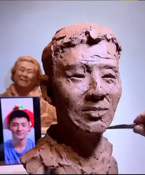 Artist sculpting facial details and contours for custom bronze portrait