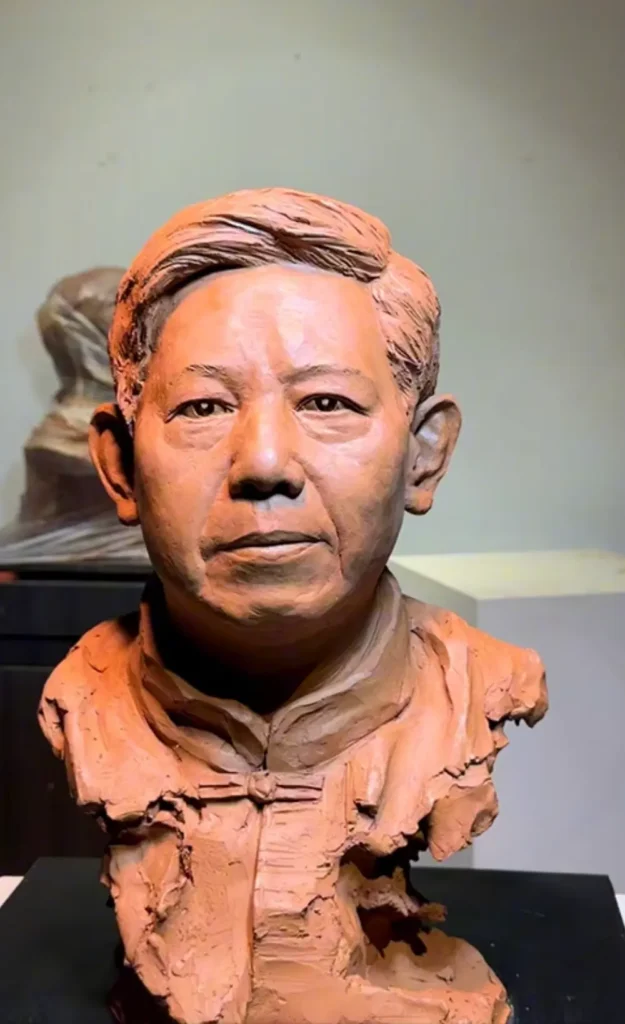 Straight-on front view of the finished clay bust, highlighting lifelike facial features, gaze, and clothing details