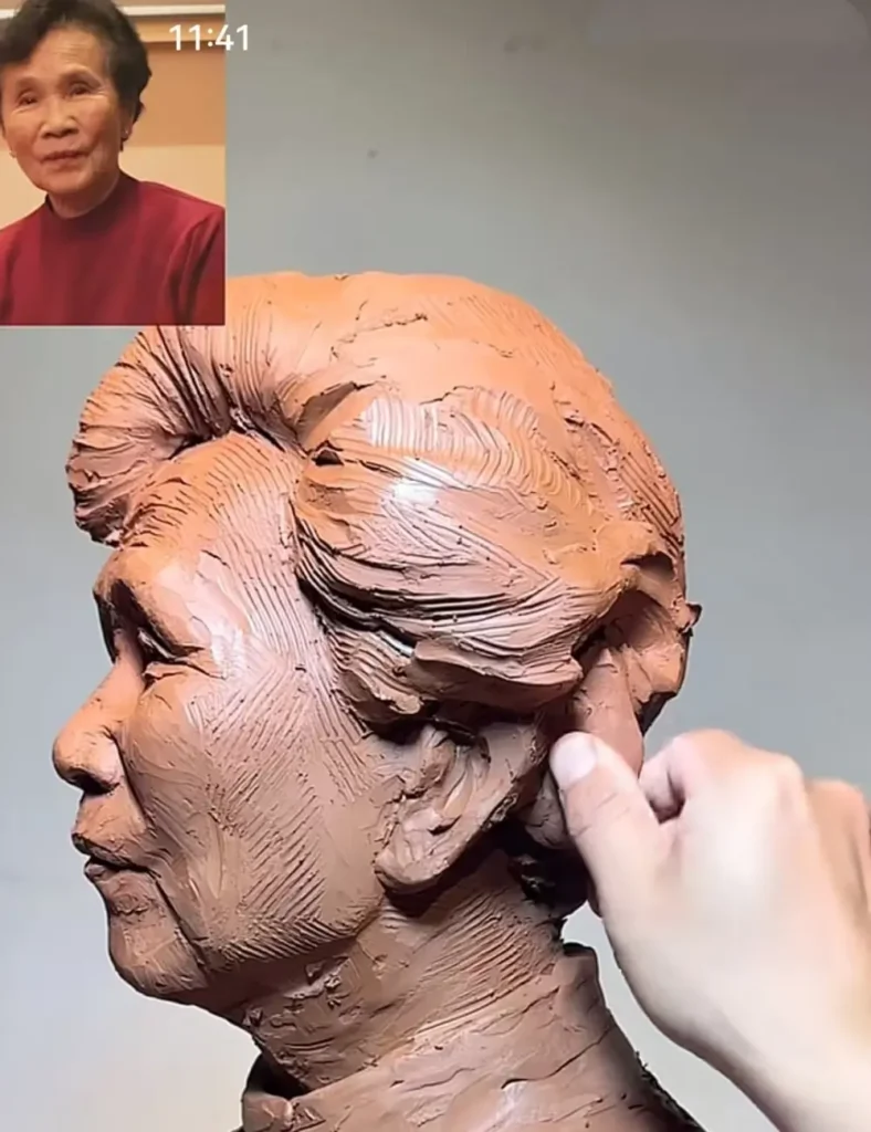 Close-up of the sculptor’s hands refining the custom memorial bronze bust for mother, focusing on hair texture and facial features
