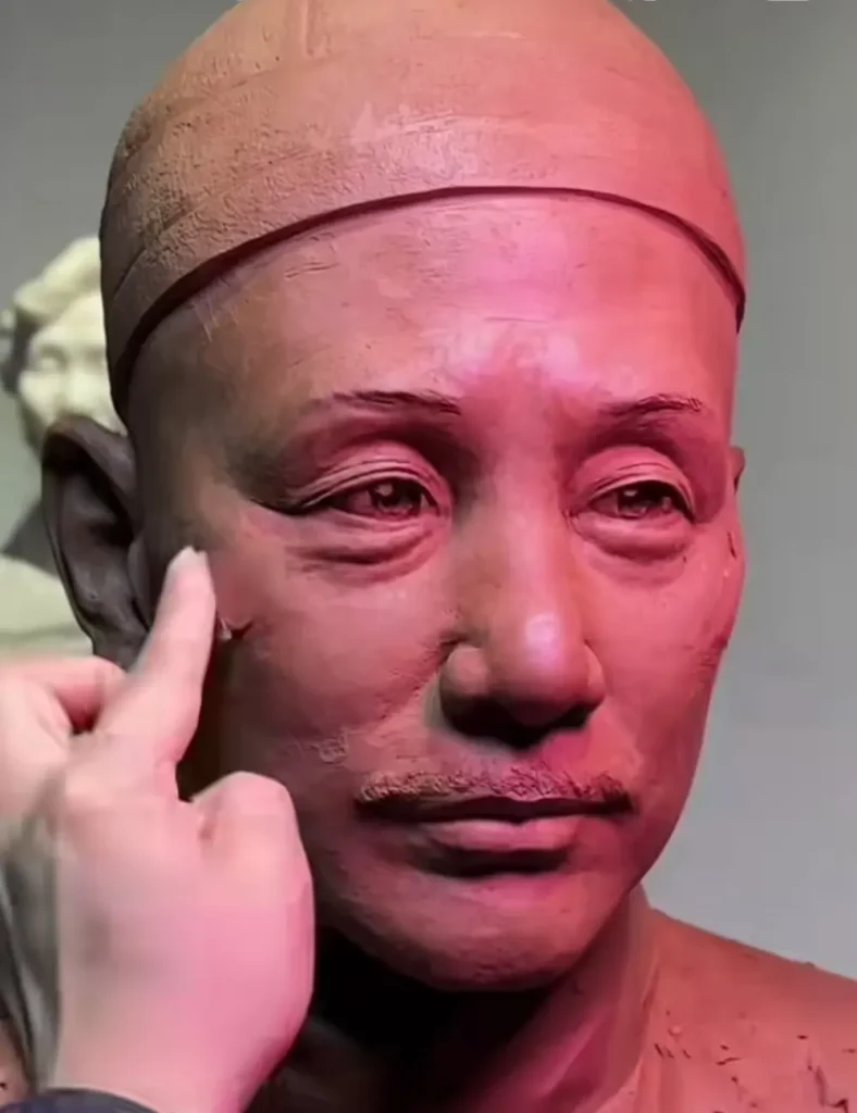 Close-up of the sculptor refining the custom memorial bronze bust for Lin Yushi, focusing on historically accurate facial details and cap texture