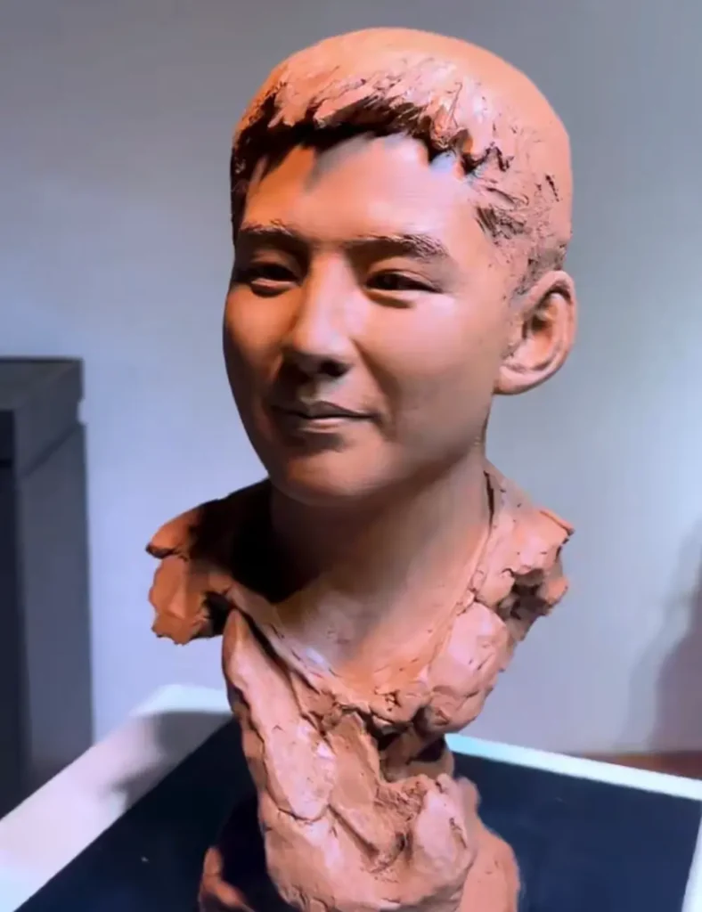 Full front view of the finished custom memorial bronze bust for a young adult, capturing his confident expression and the quiet pride of this personal milestone.